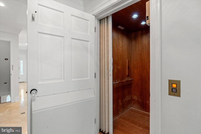 interior details featuring tile patterned flooring, ornamental molding, and elevator