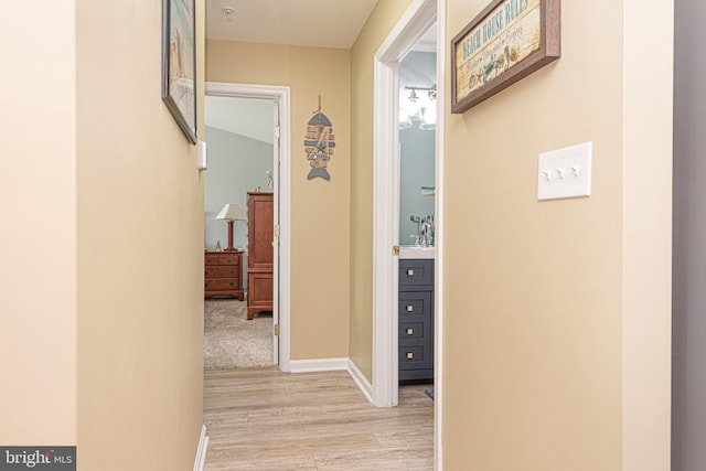 hallway with light hardwood / wood-style floors