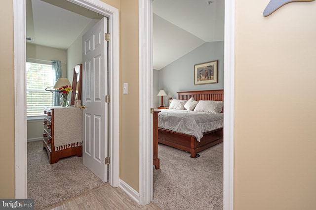 carpeted bedroom with lofted ceiling