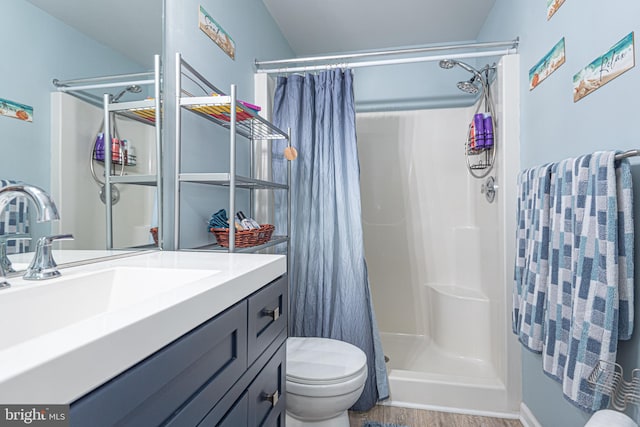 bathroom featuring walk in shower, vanity, toilet, and wood-type flooring