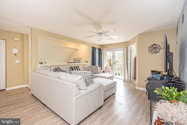 living room with light hardwood / wood-style floors and ceiling fan