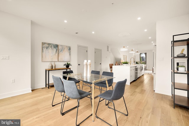 dining area with sink and light hardwood / wood-style floors