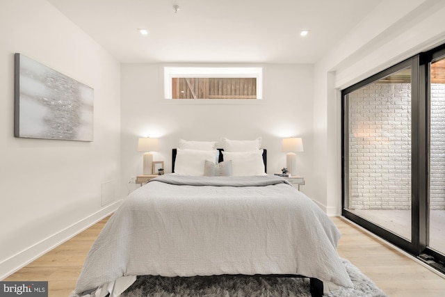 bedroom featuring access to exterior and light wood-type flooring