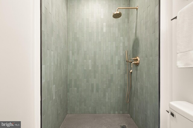 bathroom featuring toilet and tiled shower