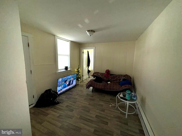 bedroom with a baseboard heating unit and dark hardwood / wood-style floors