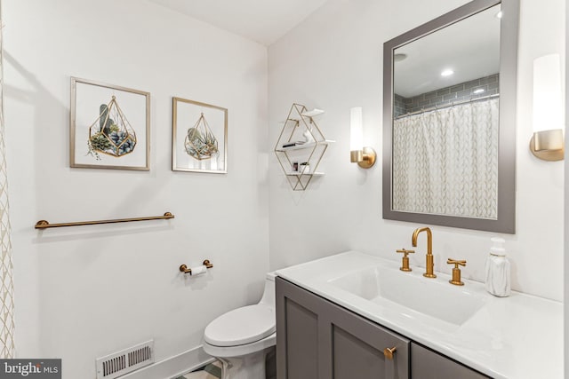 bathroom with walk in shower, vanity, and toilet