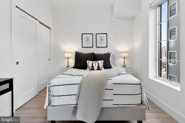 bedroom with a closet and light hardwood / wood-style floors