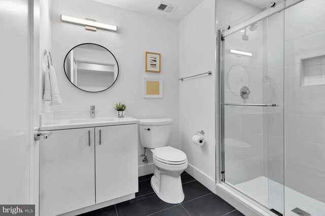 bathroom featuring tile patterned floors, a shower with shower door, vanity, and toilet