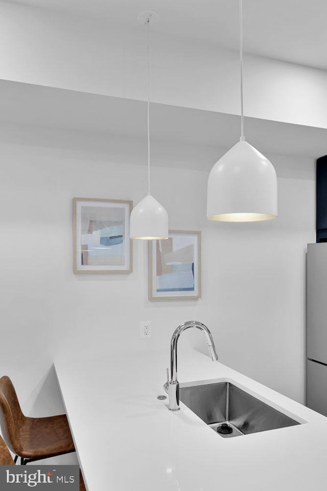 kitchen with pendant lighting, stainless steel fridge, and sink