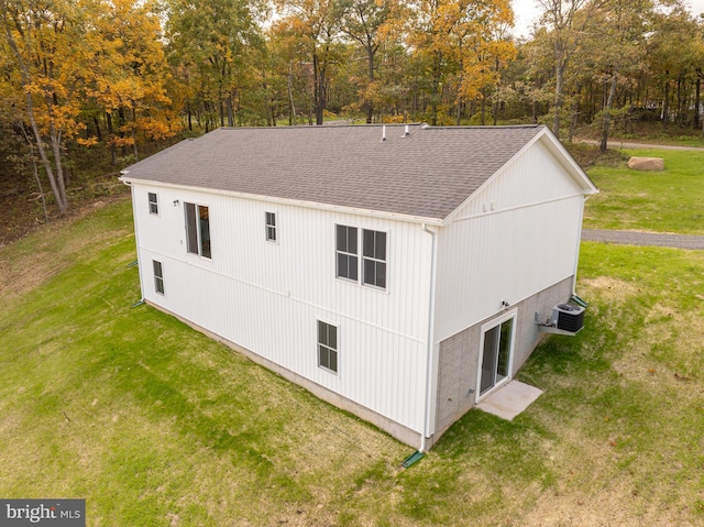 view of property exterior with cooling unit and a yard