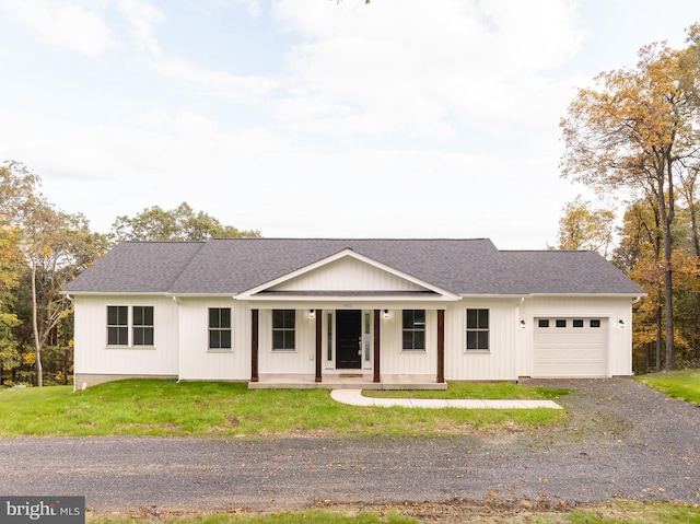 ranch-style house featuring a front yard, a garage, and a porch