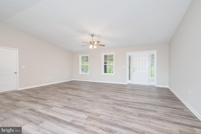 unfurnished living room with ceiling fan, vaulted ceiling, and light hardwood / wood-style floors