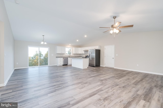 unfurnished living room with sink, vaulted ceiling, light hardwood / wood-style flooring, and ceiling fan