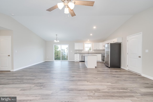 unfurnished living room with ceiling fan, sink, light hardwood / wood-style flooring, and vaulted ceiling