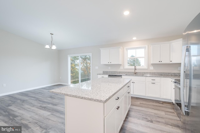 kitchen featuring a wealth of natural light, light hardwood / wood-style floors, white cabinetry, and a kitchen island