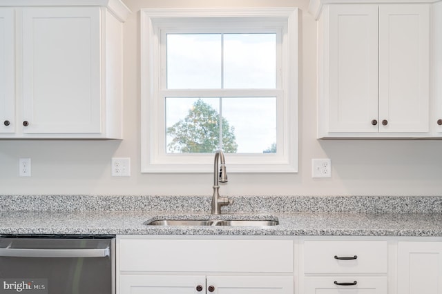 kitchen featuring dishwasher, plenty of natural light, white cabinets, and sink