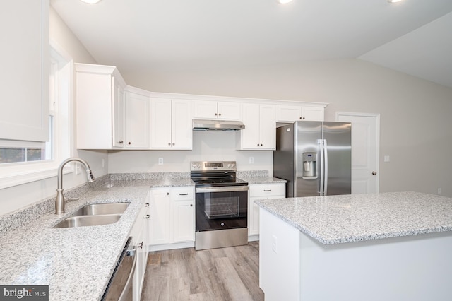 kitchen featuring light wood-type flooring, sink, stainless steel appliances, lofted ceiling, and white cabinetry