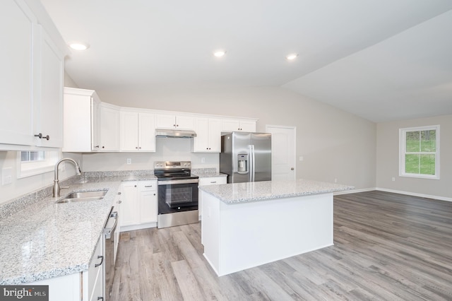 kitchen with light wood-type flooring, a kitchen island, sink, stainless steel appliances, and lofted ceiling