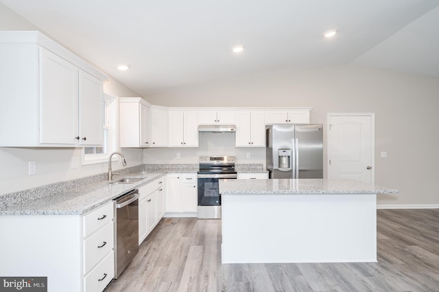 kitchen featuring a center island, white cabinets, sink, vaulted ceiling, and appliances with stainless steel finishes