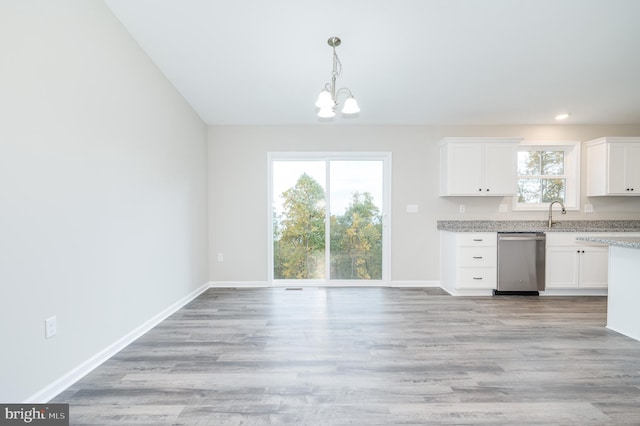 kitchen with light wood-type flooring, decorative light fixtures, a notable chandelier, dishwasher, and white cabinets