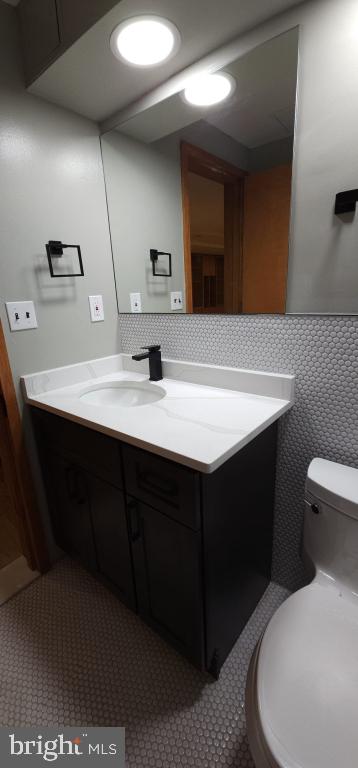 bathroom with tile patterned flooring, vanity, and toilet