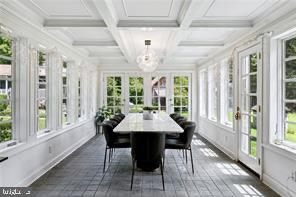 sunroom / solarium featuring french doors, beamed ceiling, coffered ceiling, and a wealth of natural light