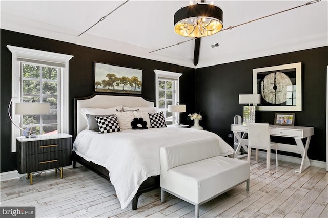 bedroom with visible vents, baseboards, a notable chandelier, and wood finished floors