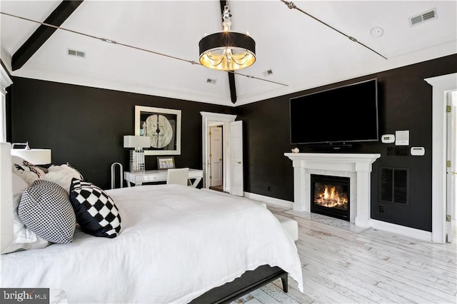 bedroom with a fireplace, visible vents, and vaulted ceiling