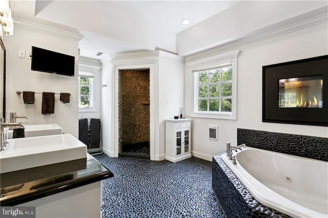 full bath featuring a stall shower, double vanity, baseboards, and a tub with jets