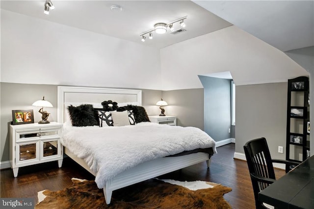 bedroom featuring wood finished floors, baseboards, rail lighting, and visible vents