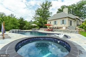 view of pool featuring a patio and an in ground hot tub