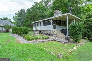 view of side of property featuring a yard and a sunroom