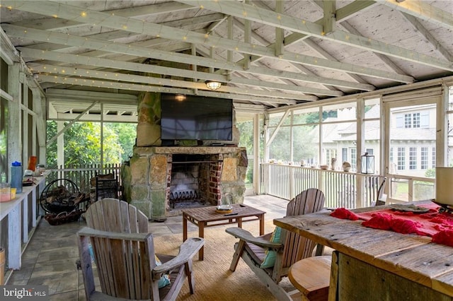 sunroom / solarium with an outdoor stone fireplace and plenty of natural light