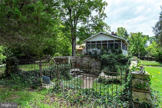 rear view of house featuring fence, a sunroom, and a chimney