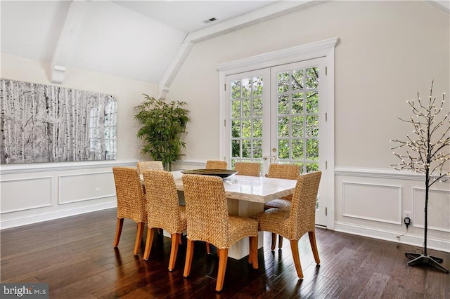 dining space with a decorative wall, visible vents, dark wood-style flooring, wainscoting, and lofted ceiling