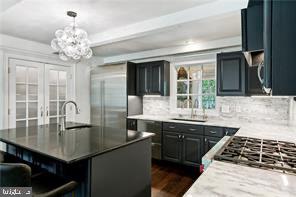 kitchen featuring dark hardwood / wood-style floors, sink, a kitchen island, an inviting chandelier, and decorative light fixtures