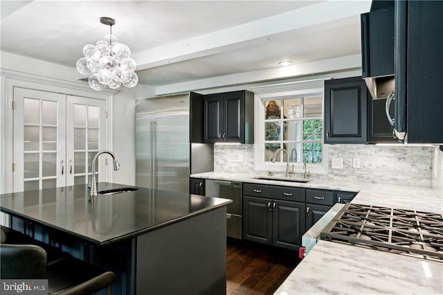kitchen with tasteful backsplash, a sink, dark wood-style floors, and stainless steel appliances
