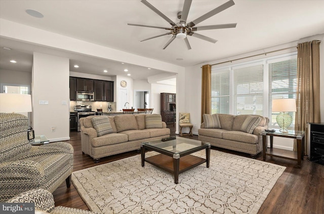 living room featuring dark hardwood / wood-style flooring and ceiling fan