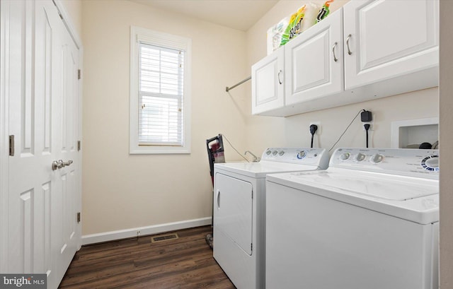 clothes washing area with dark hardwood / wood-style flooring, cabinets, and washer and dryer