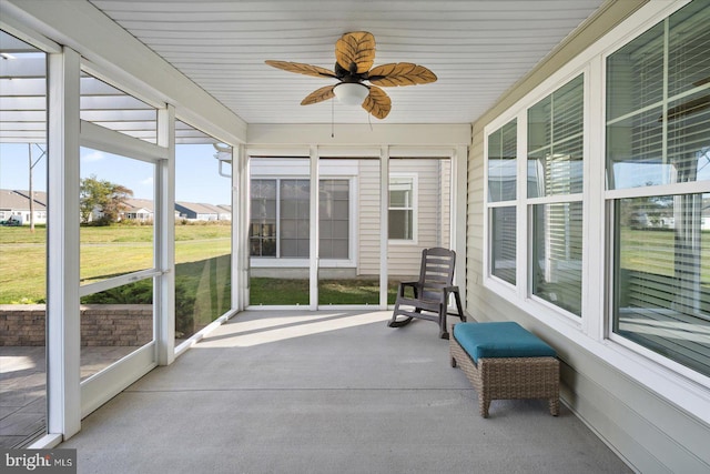 unfurnished sunroom featuring ceiling fan