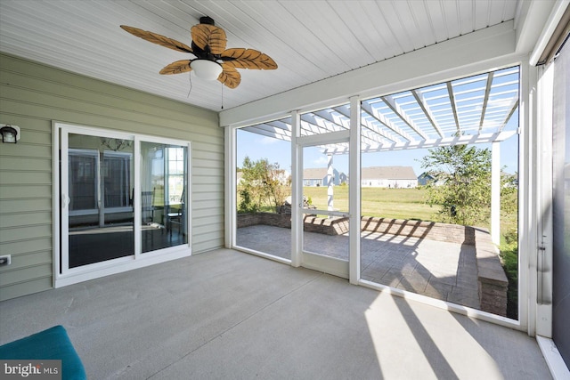 unfurnished sunroom featuring ceiling fan