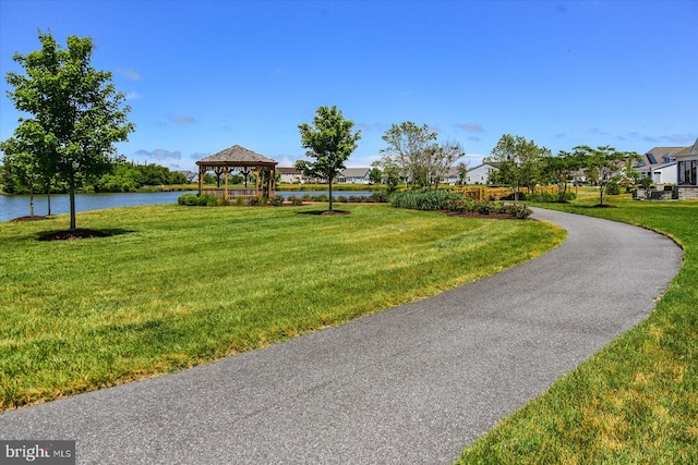 view of community with a lawn, a gazebo, and a water view