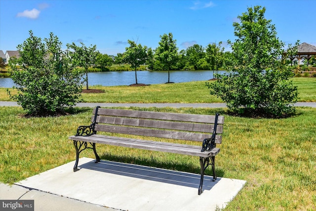 surrounding community featuring a water view and a lawn