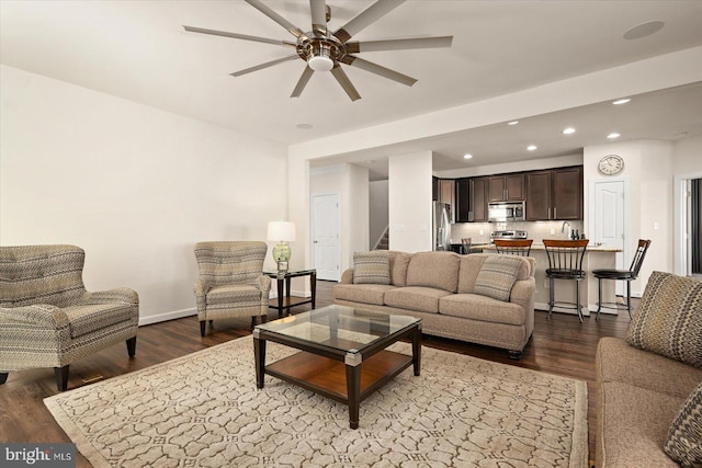 living room with wood-type flooring, ceiling fan, and sink