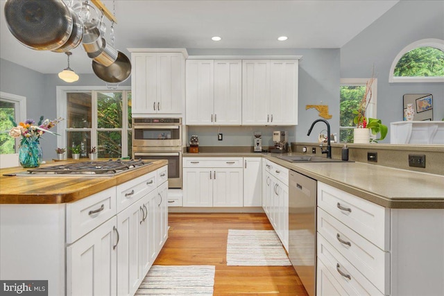 kitchen featuring a healthy amount of sunlight, stainless steel appliances, and white cabinets