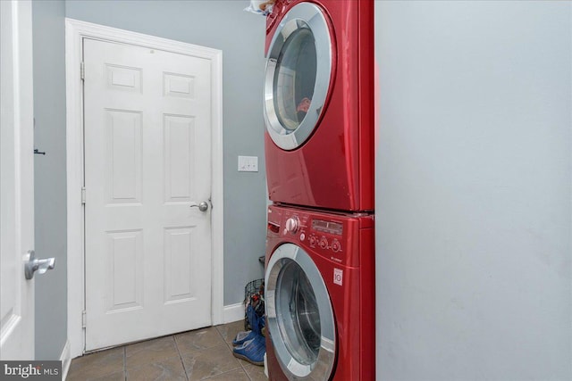 washroom with stacked washer / drying machine and tile patterned floors