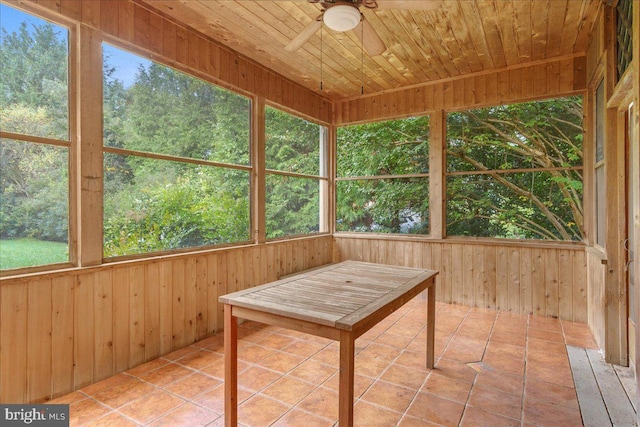 unfurnished sunroom with ceiling fan, wood ceiling, and a healthy amount of sunlight