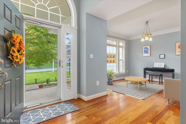 entryway featuring ornamental molding, a notable chandelier, and hardwood / wood-style flooring