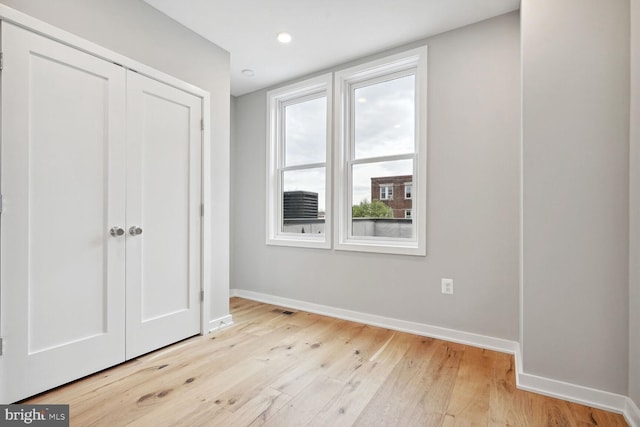 unfurnished bedroom with a closet and light hardwood / wood-style floors