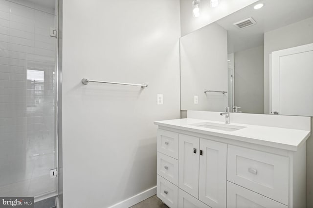 bathroom with a shower with door and vanity